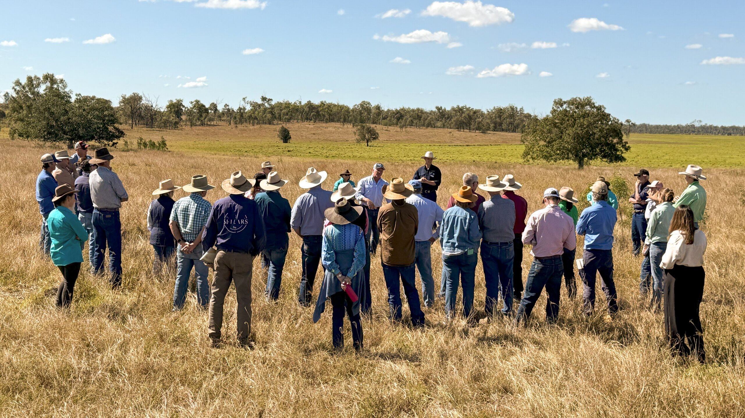 A group of people standing in a field at FBA's Cattle, Carbon and Cash Workshop