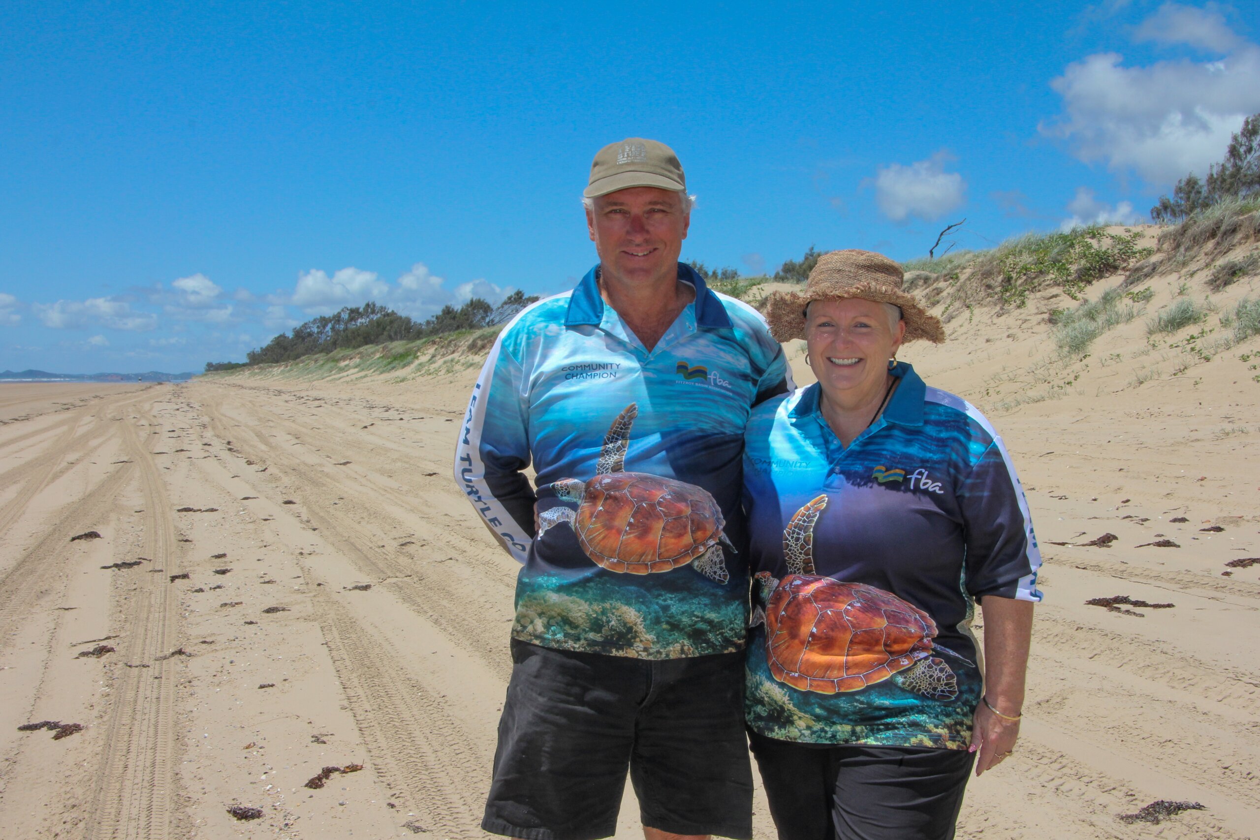 Two volunteers of FBA Team Turtle CQ standing at the beach smiling at the camera