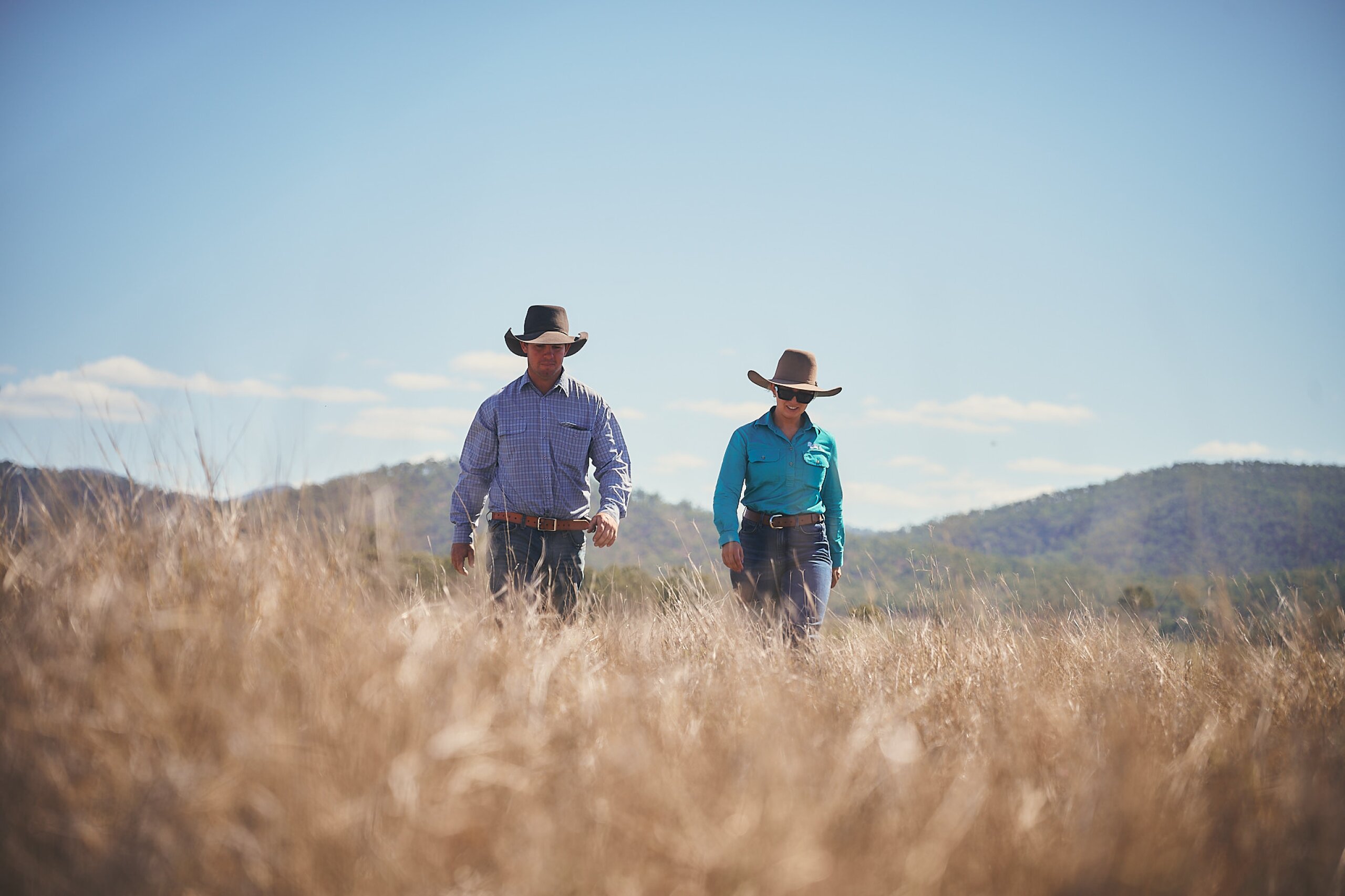 A land manager and an FBA staff member walking through a field towards the camera