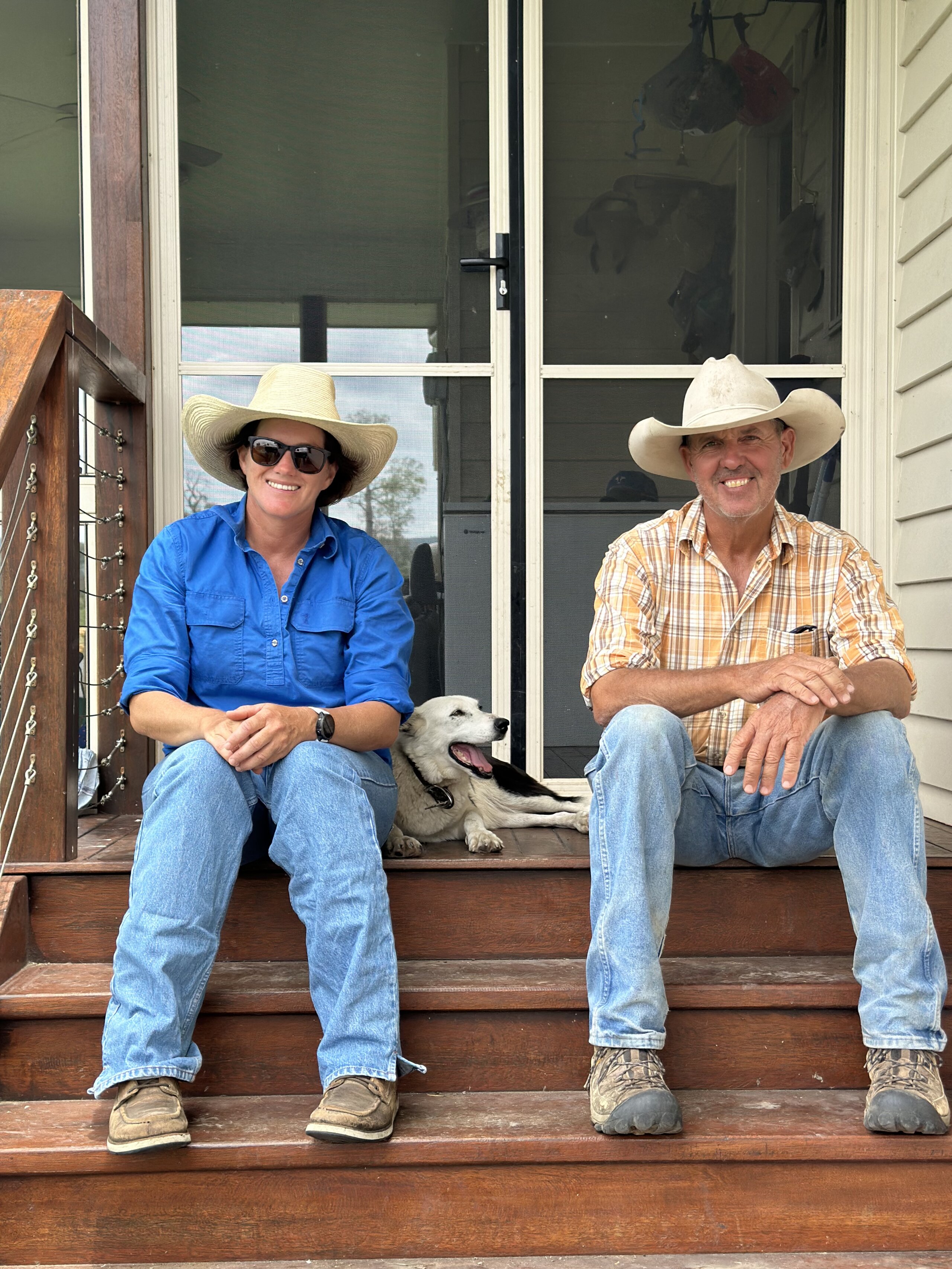 A couple sitting on their veranda together with their dog