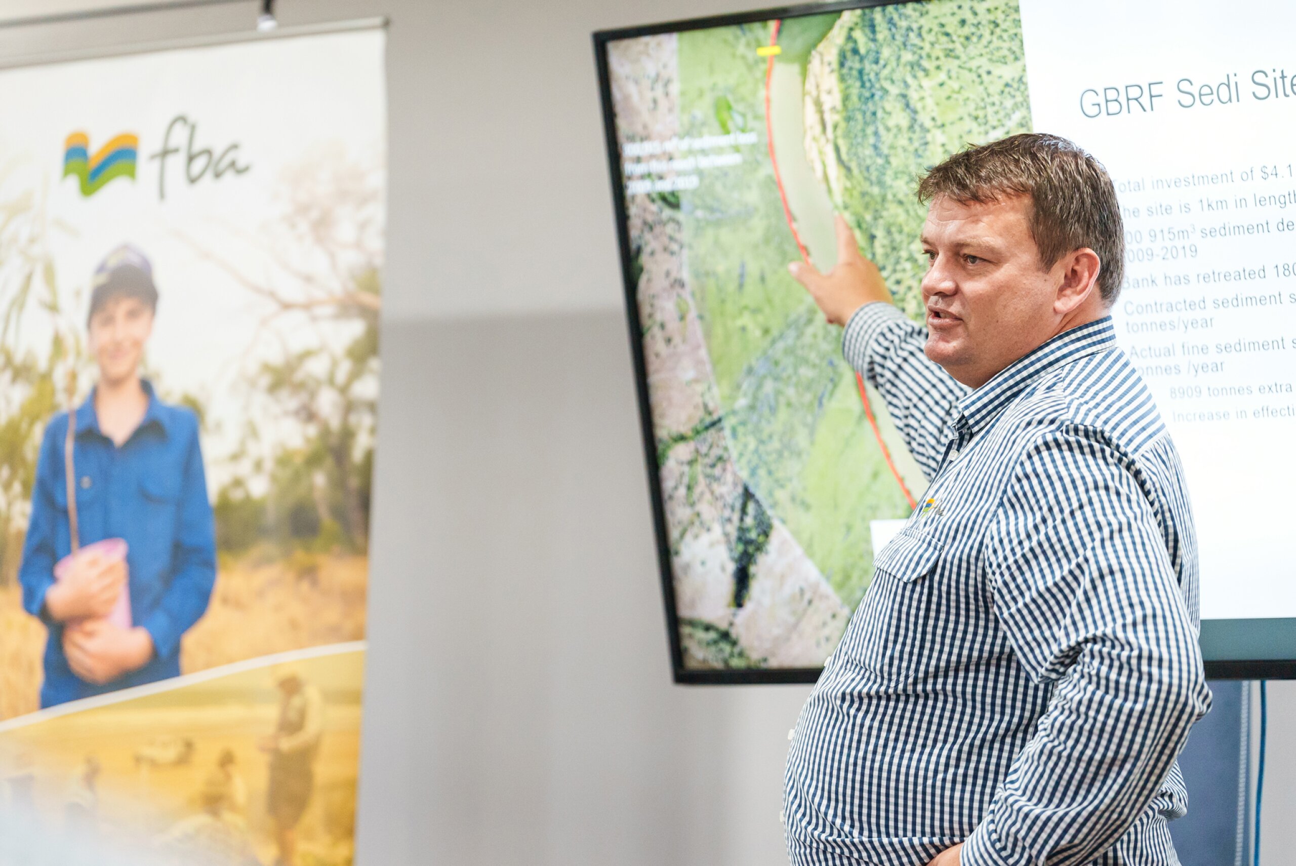 A man holding a presentation pointing to a screen