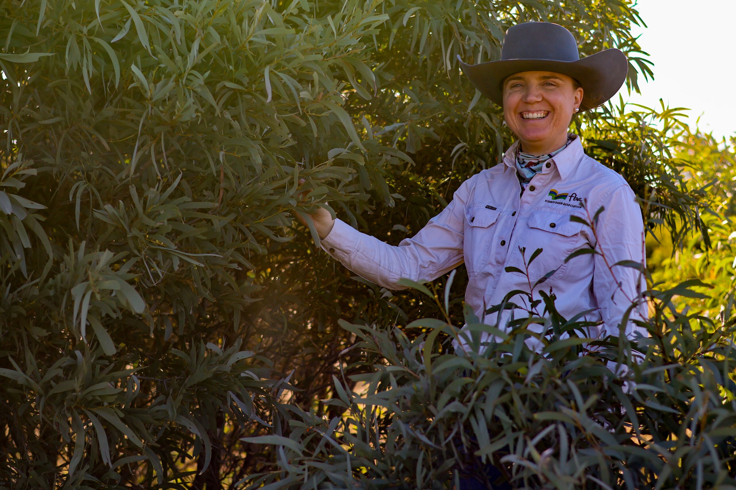 An FBA staff member standing next to brigalow regrowth