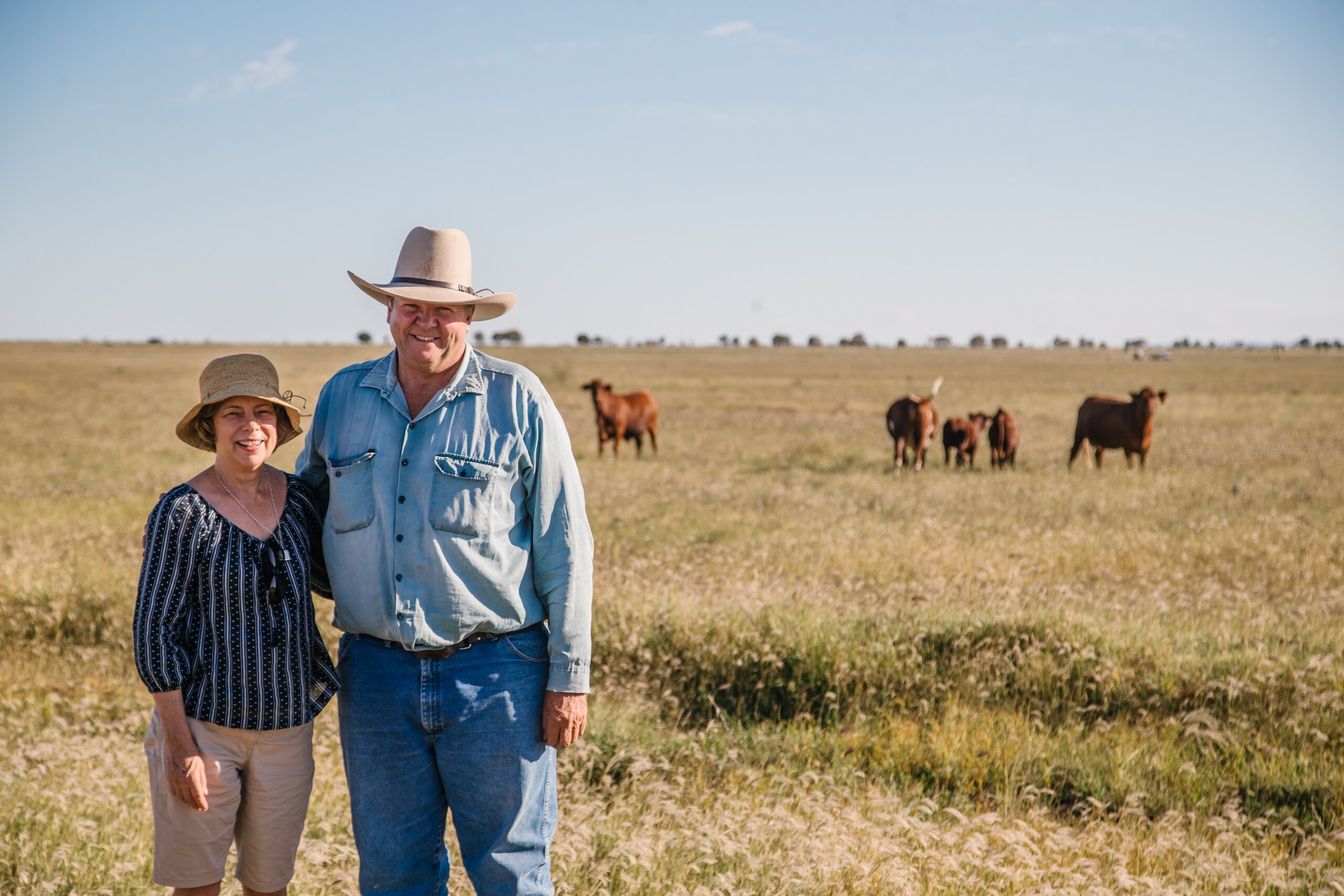 A land manager couple on their property smiling at the camera