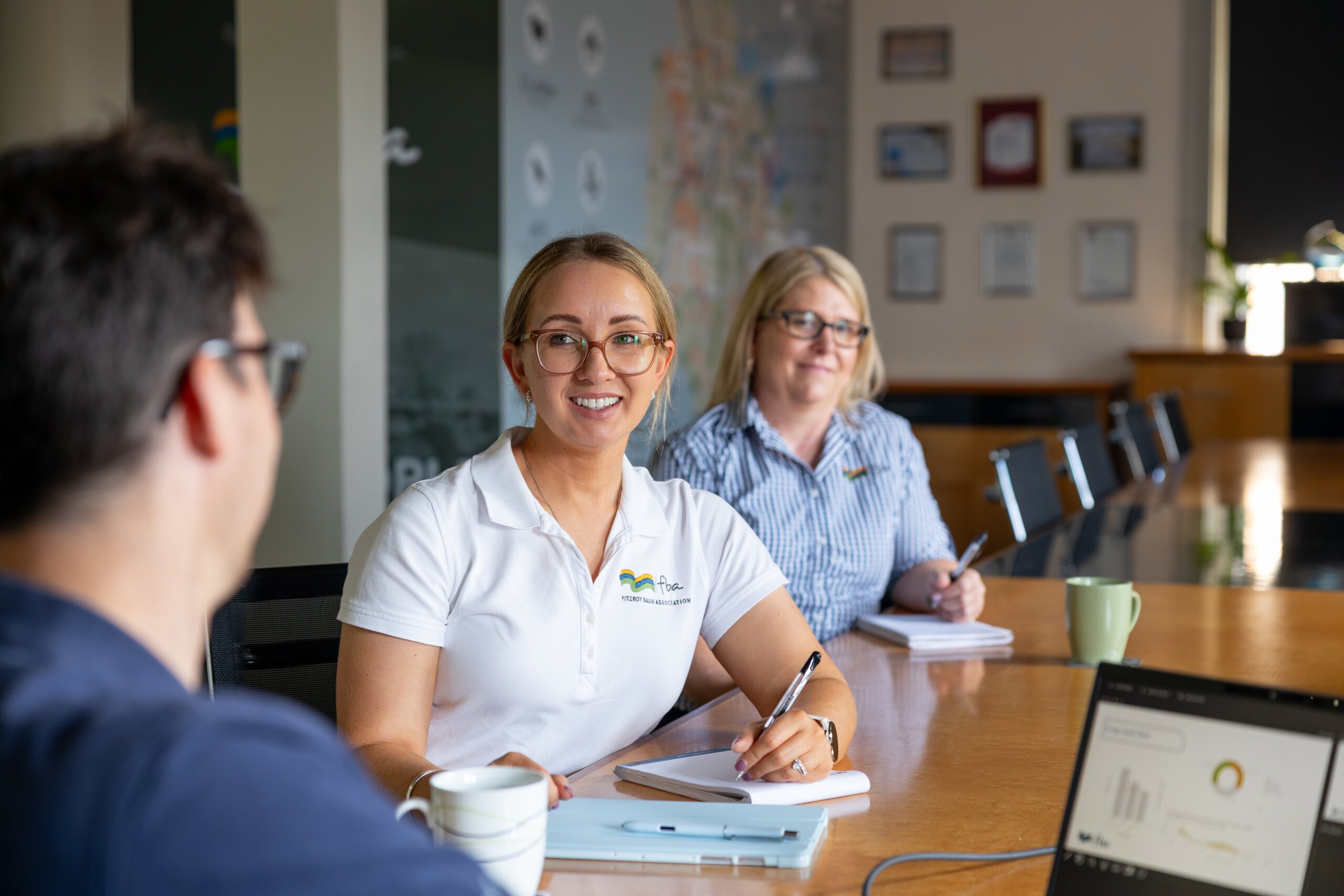 FBA staff members sit in a meeting at a boardroom table in the Rockhampton office