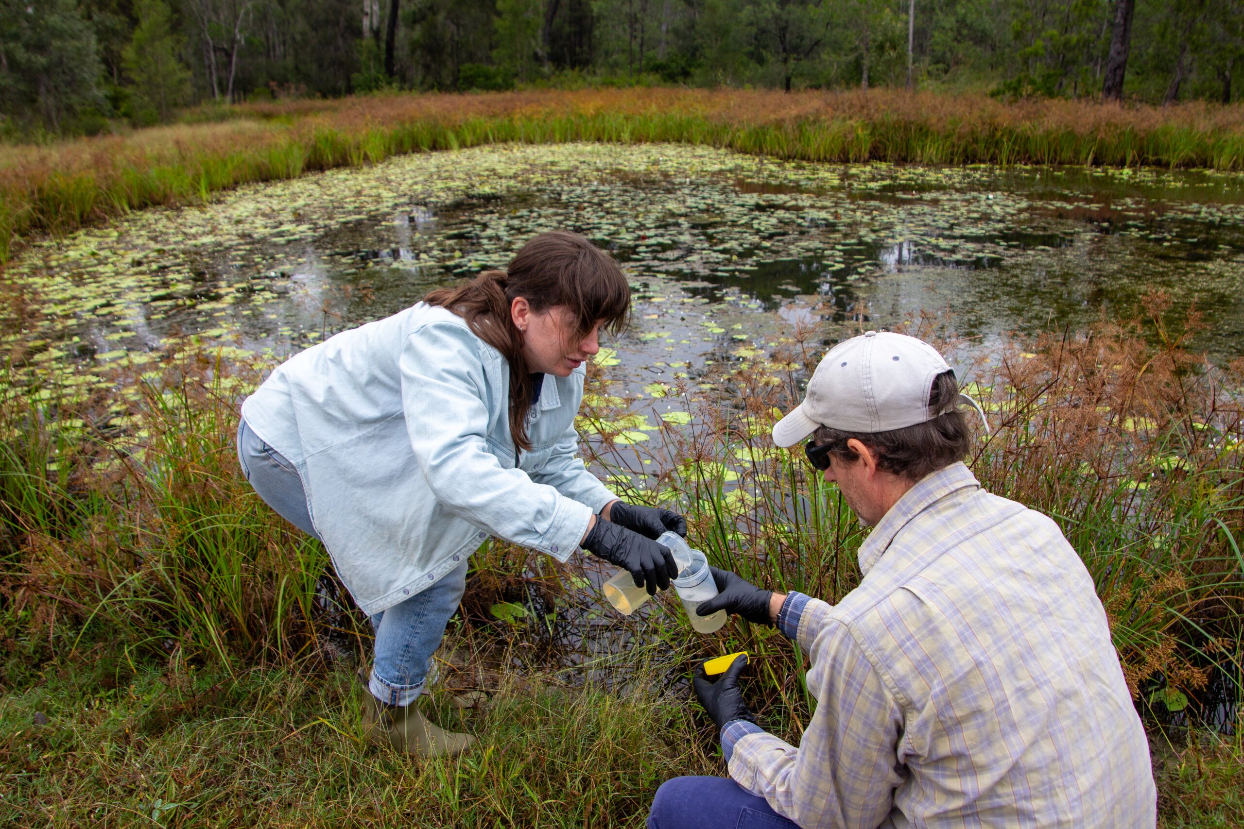 Two FBA staff members collecting water samples for TropWATER