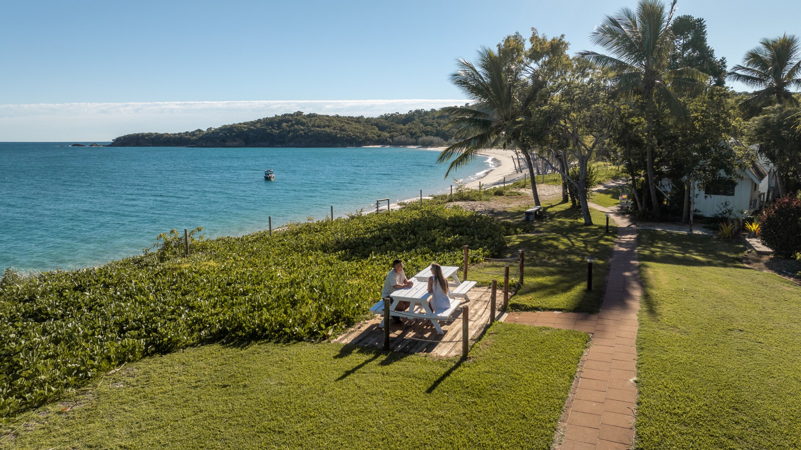 Couple sitting on a picnic table overlooking Great Keppel Island