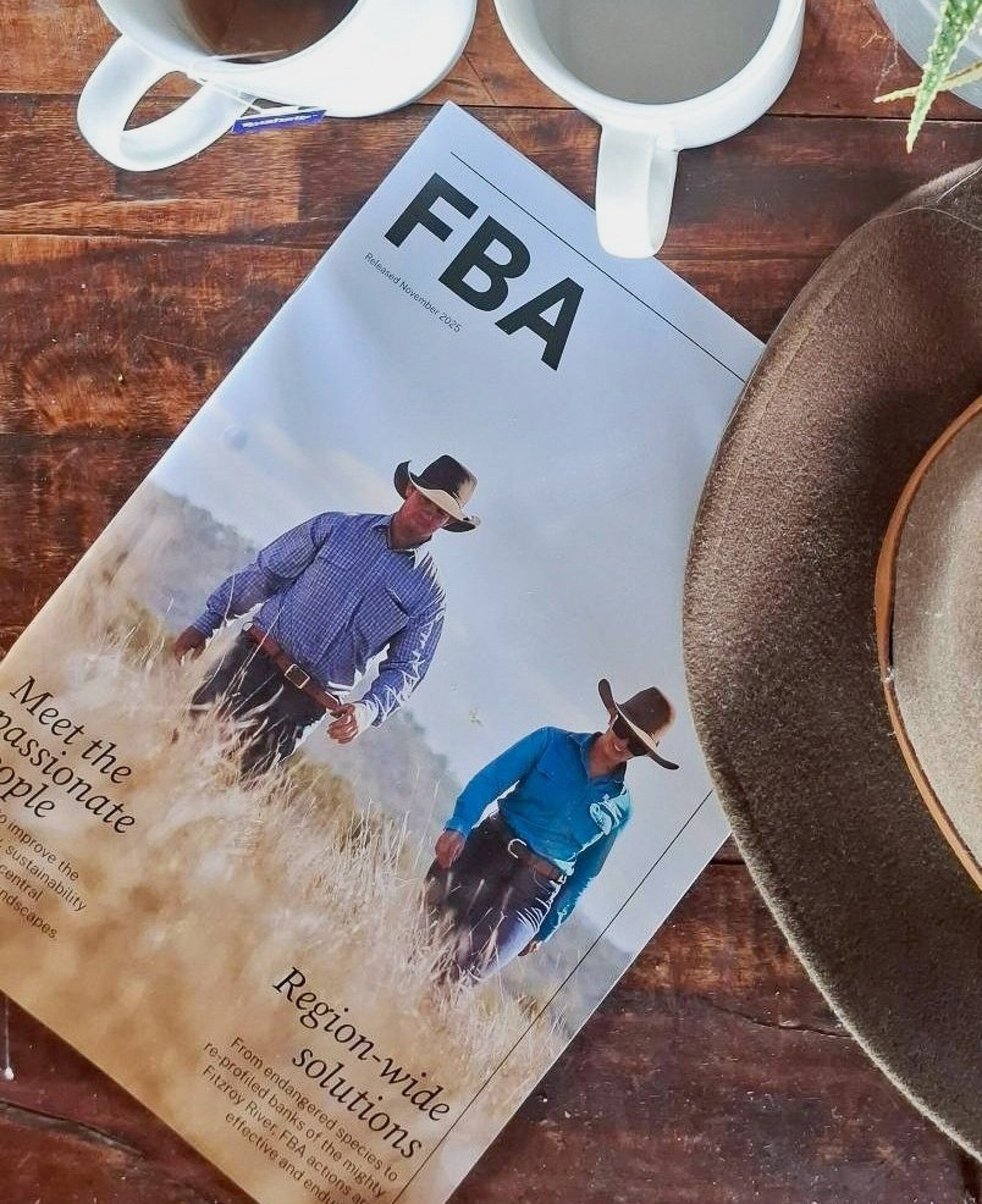 FBA Magazine laying on a table next to a land manager's hat and two cups of tea.