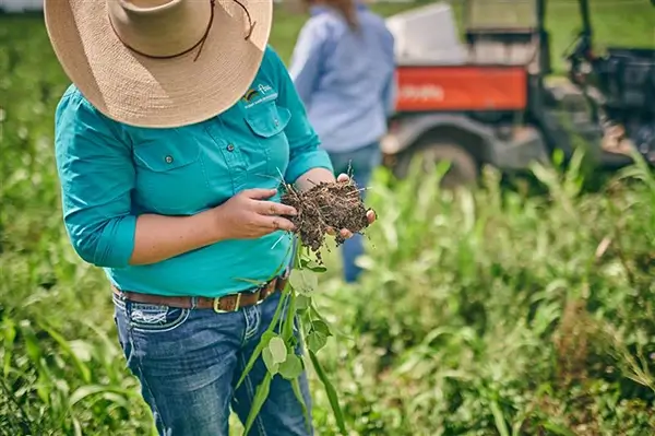 An FBA staff member examines some soil while on a property visit.